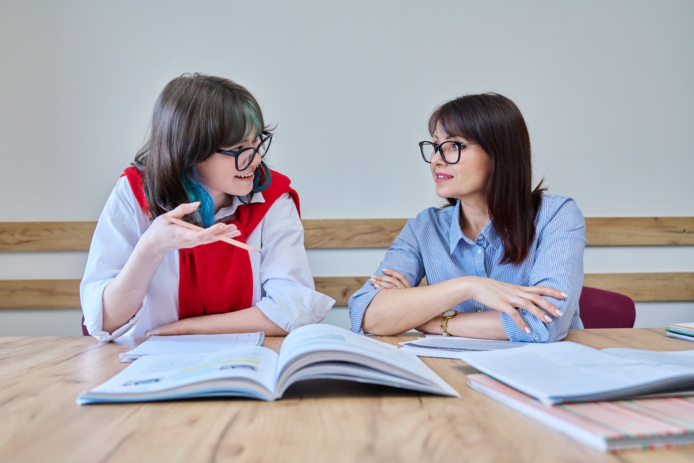 Young teenage female studying foreign languages in course with teacher